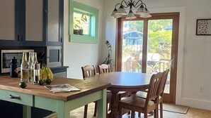A kitchen with a dining table, chairs, and a window with a view of the outdoors. - Charming 2-bedroom bungalow in Seward Park (Seattle)