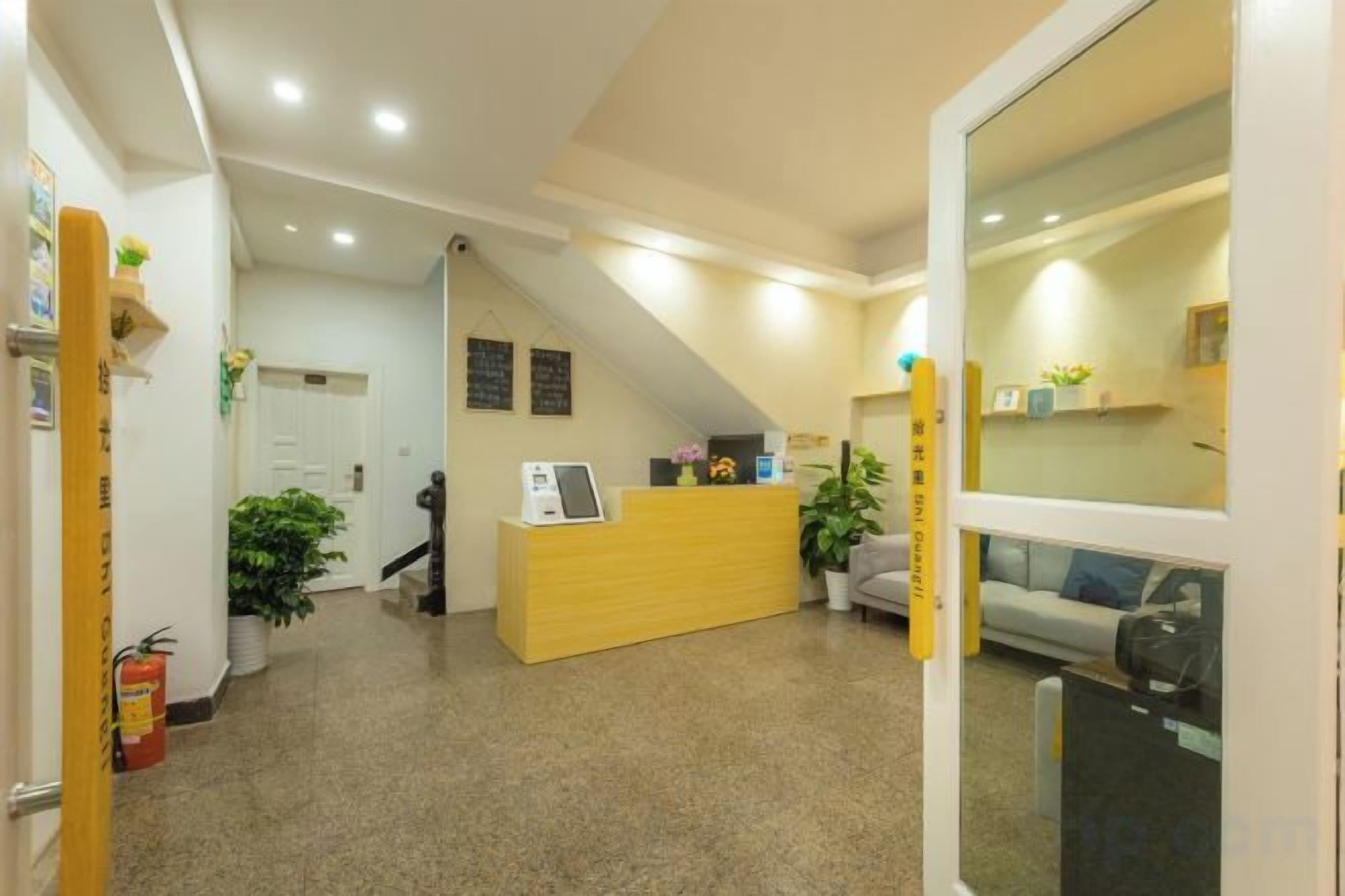A reception area with a desk, a seating area, and a staircase leading to an upper level.
