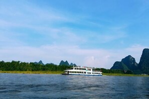 A boat on water with mountains in the background. - Shiguangli Homestay (Yangshuo West Street) (Yangshuo)