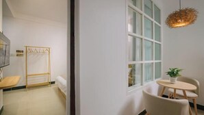 Ein Zimmer mit einem Bett, einem kleinen Tisch mit Stühlen, einer Hängelampe und einem Fenster mit Blick.