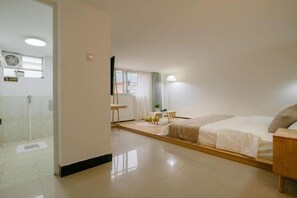 A hotel room with a bed, bedside table, a small table with chairs, a window, and a door leading to a bathroom. - Shiguangli Homestay (Yangshuo West Street) (Yangshuo)