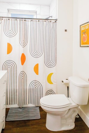 A bathroom with a toilet, a shower curtain with geometric patterns, and a wooden floor. - Spacious Lux Cincinnati Group Retreat: Sauna/Spa, Fire pit, 5 min DT (Cincinnati)