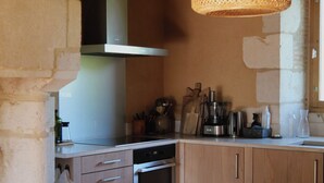 A kitchen with wooden cabinets, a stove, and a dining table with chairs.