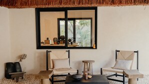 Ein Zimmer mit einem großen Spiegel, zwei Stühlen, einem Tisch und einem kleinen Hocker.