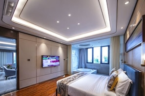 A modern hotel room with a bed, TV, and a view of the outdoors.