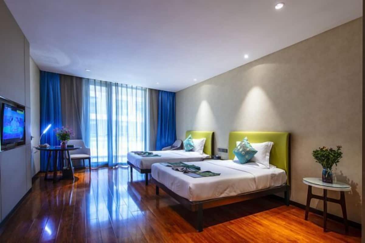 Een hotelkamer met twee bedden, een bureau en een televisie.