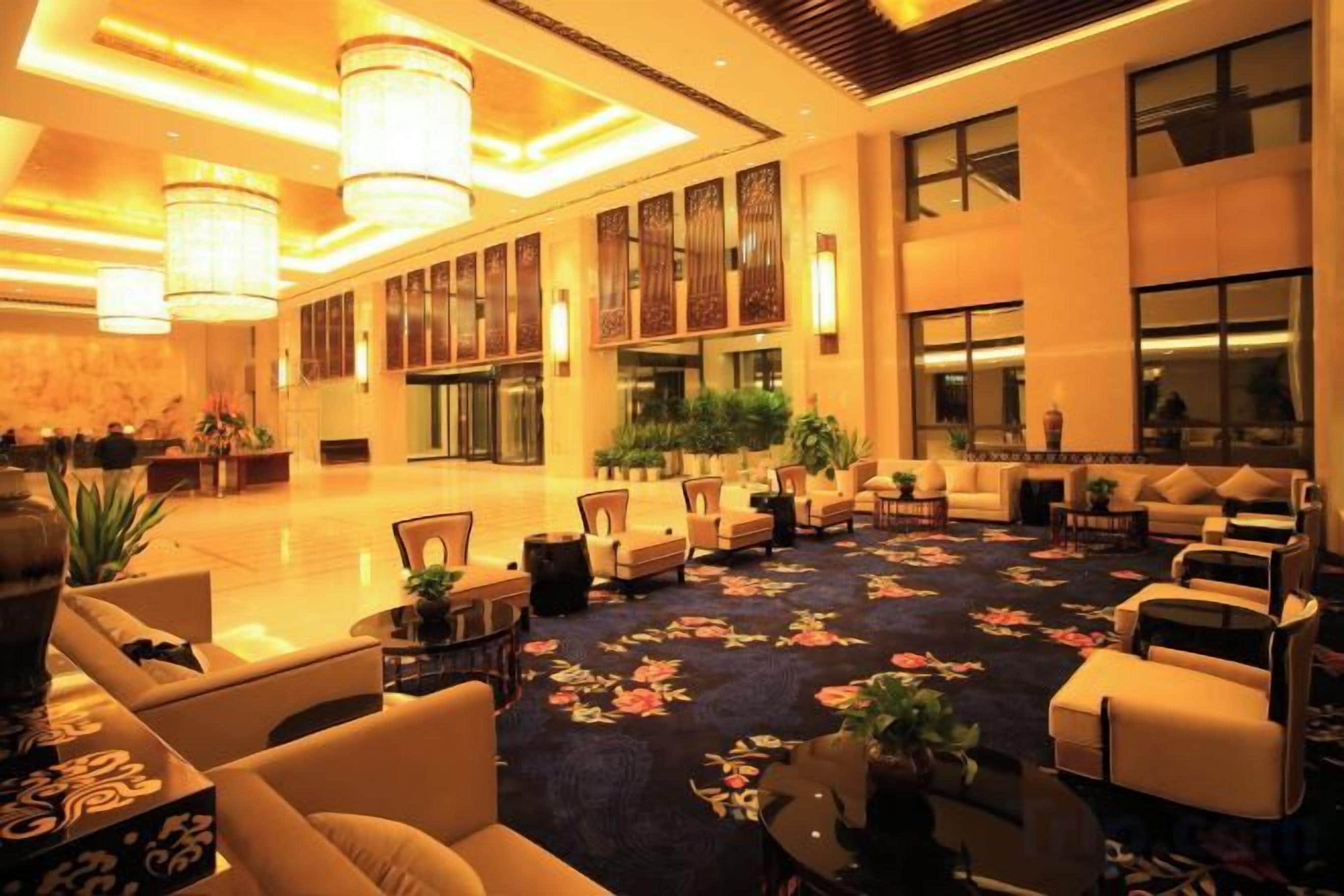 A spacious lobby with a carpeted floor, seating areas, and large windows.