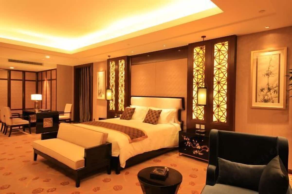 Een hotelkamer met een groot bed, een slaapbank, een bureau en een stoel.