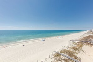 Ein Strand mit einem hölzernen Promenadenweg und Strandstühlen.