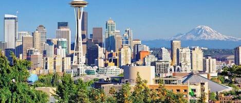 A cityscape with a prominent tower and a mountain in the background.