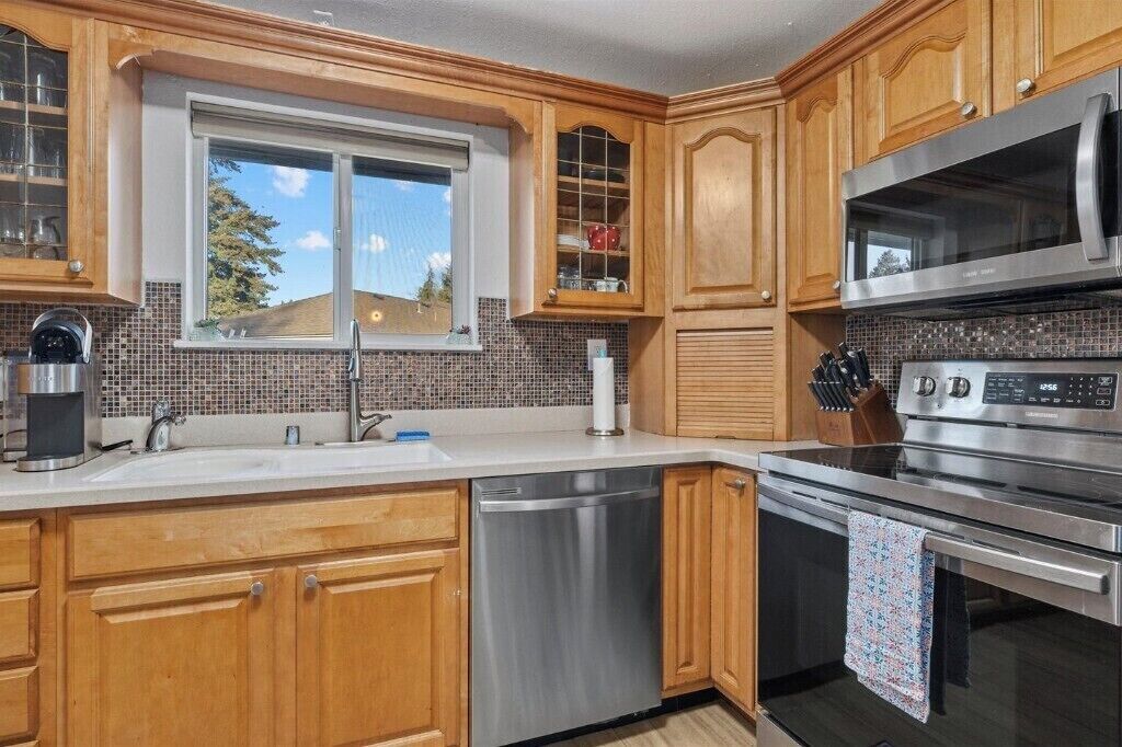 A kitchen with wooden cabinets, a stainless steel dishwasher, a microwave, and an oven.