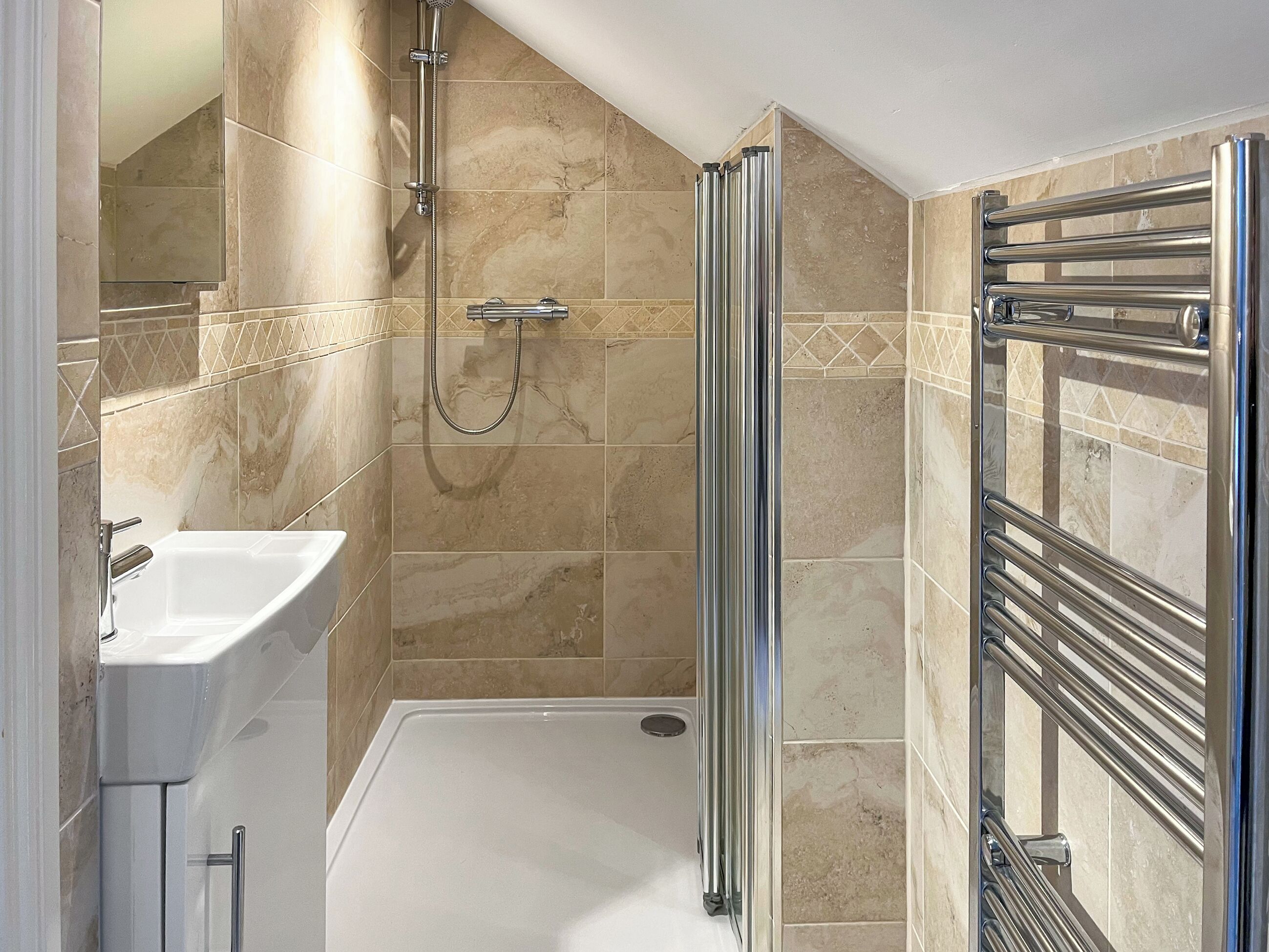 A modern bathroom with a walk-in shower, a standalone bathtub, and a glass-enclosed shower stall.