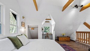 Une chambre avec un grand lit, un bureau et une vue sur l’extérieur.