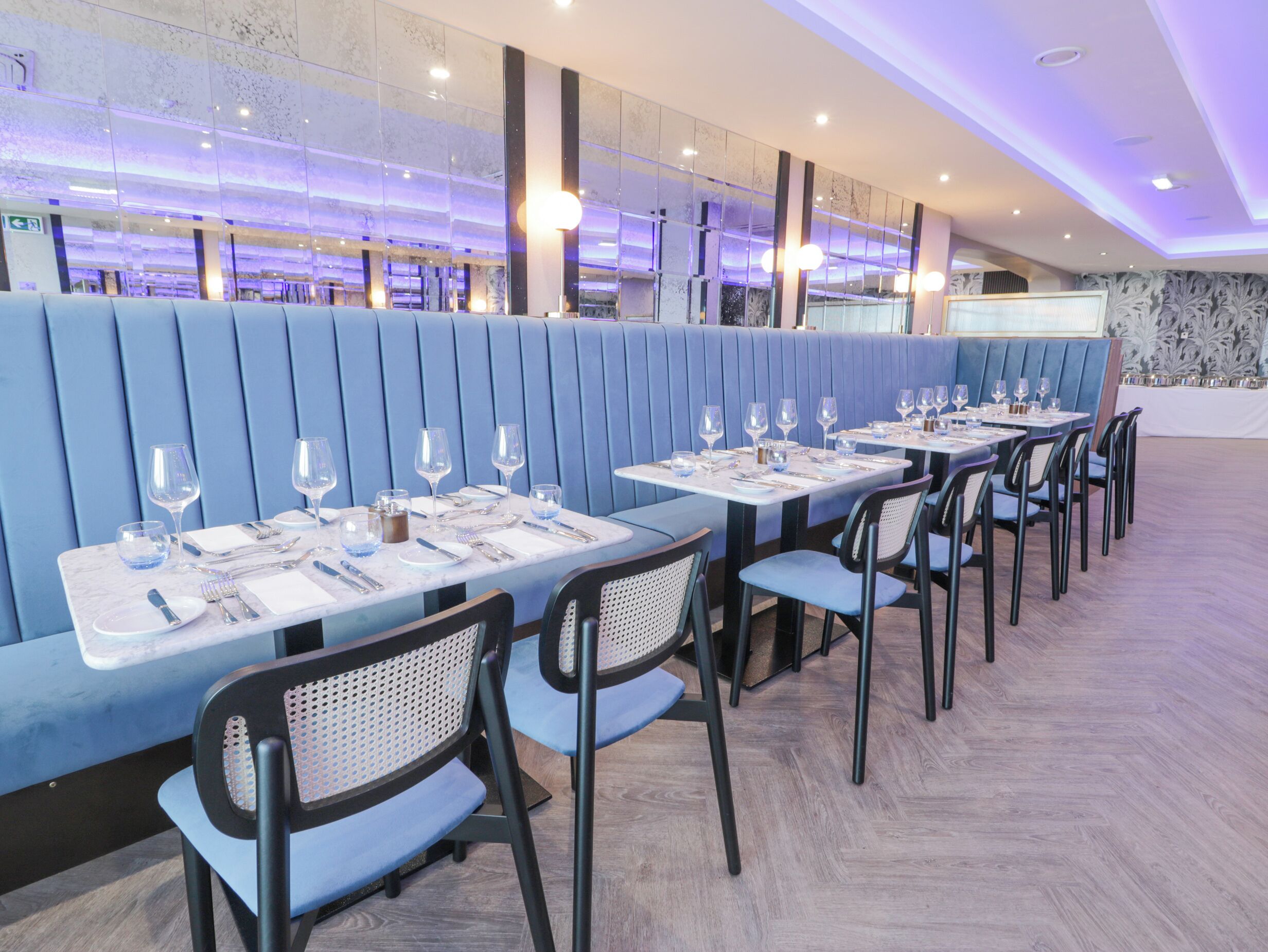 Un restaurante con asientos y mesas dispuestas para comer, que presenta un diseño interior moderno.