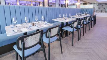 Un restaurante con asientos y mesas dispuestas para comer, que presenta un diseño interior moderno.