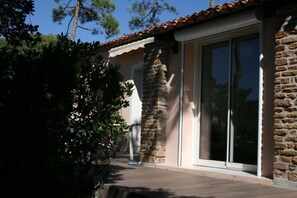 A building with a stone facade, large glass sliding doors, and a wooden deck.
