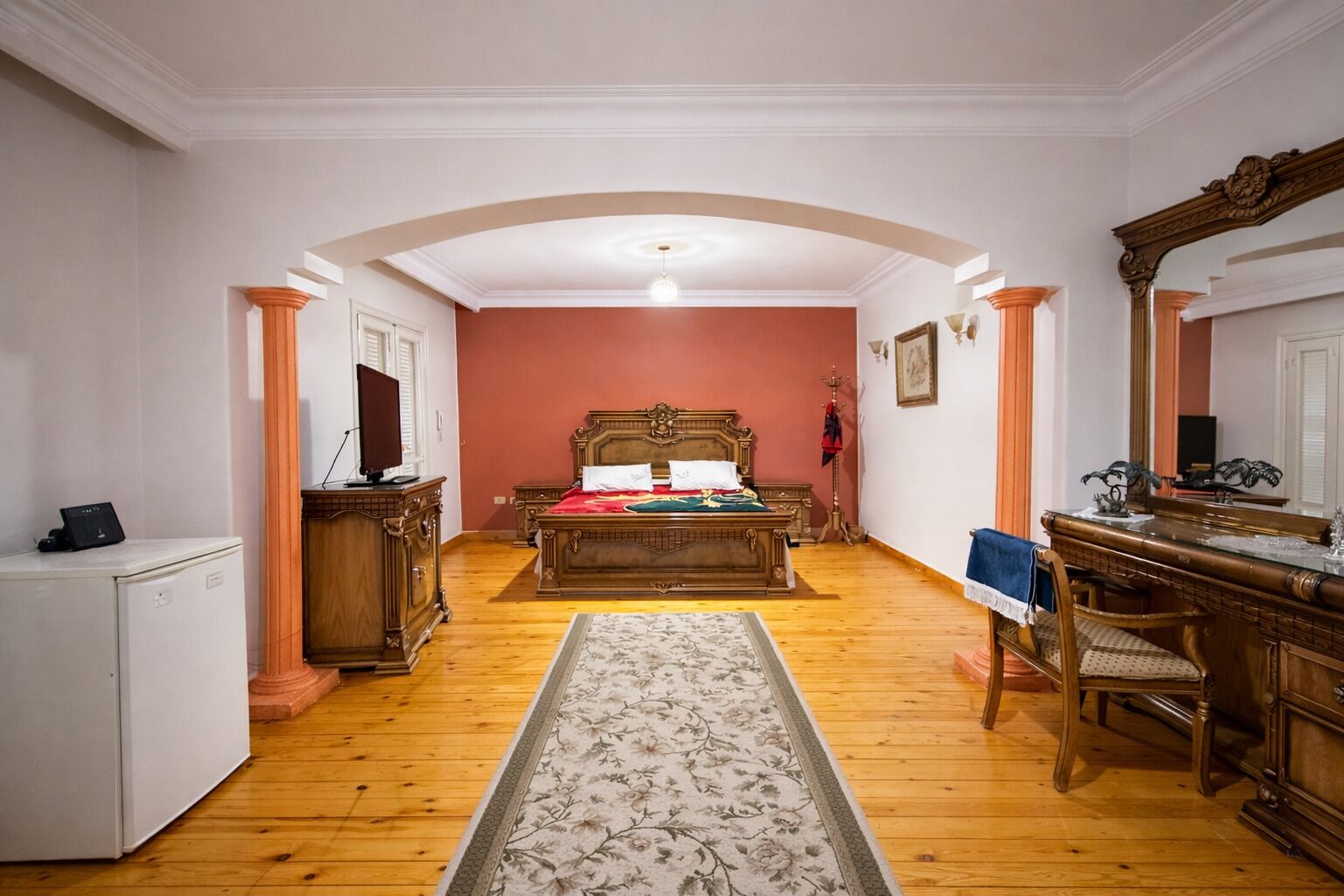 Une chambre comprenant un lit, un bureau, une chaise et un petit réfrigérateur.