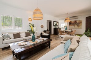 A modern living room with a sofa, coffee table, and dining area.