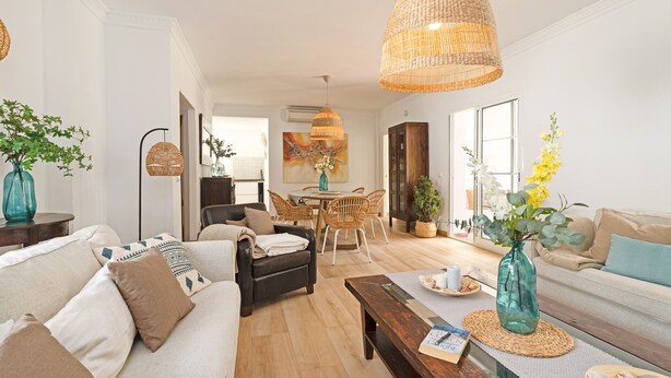 A modern living room with a sofa, coffee table, and dining area.