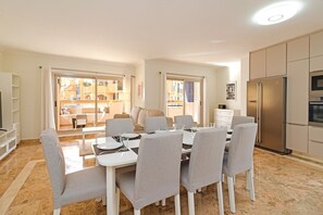 A modern kitchen with a built-in oven and a stainless steel refrigerator.