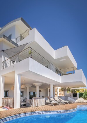 Relax by the outdoor pool on a spacious deck with lounge chairs.