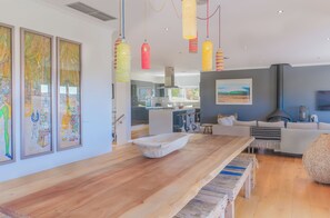 Relax in this stylish living space with a dining table, comfortable sofa, and vibrant artwork.