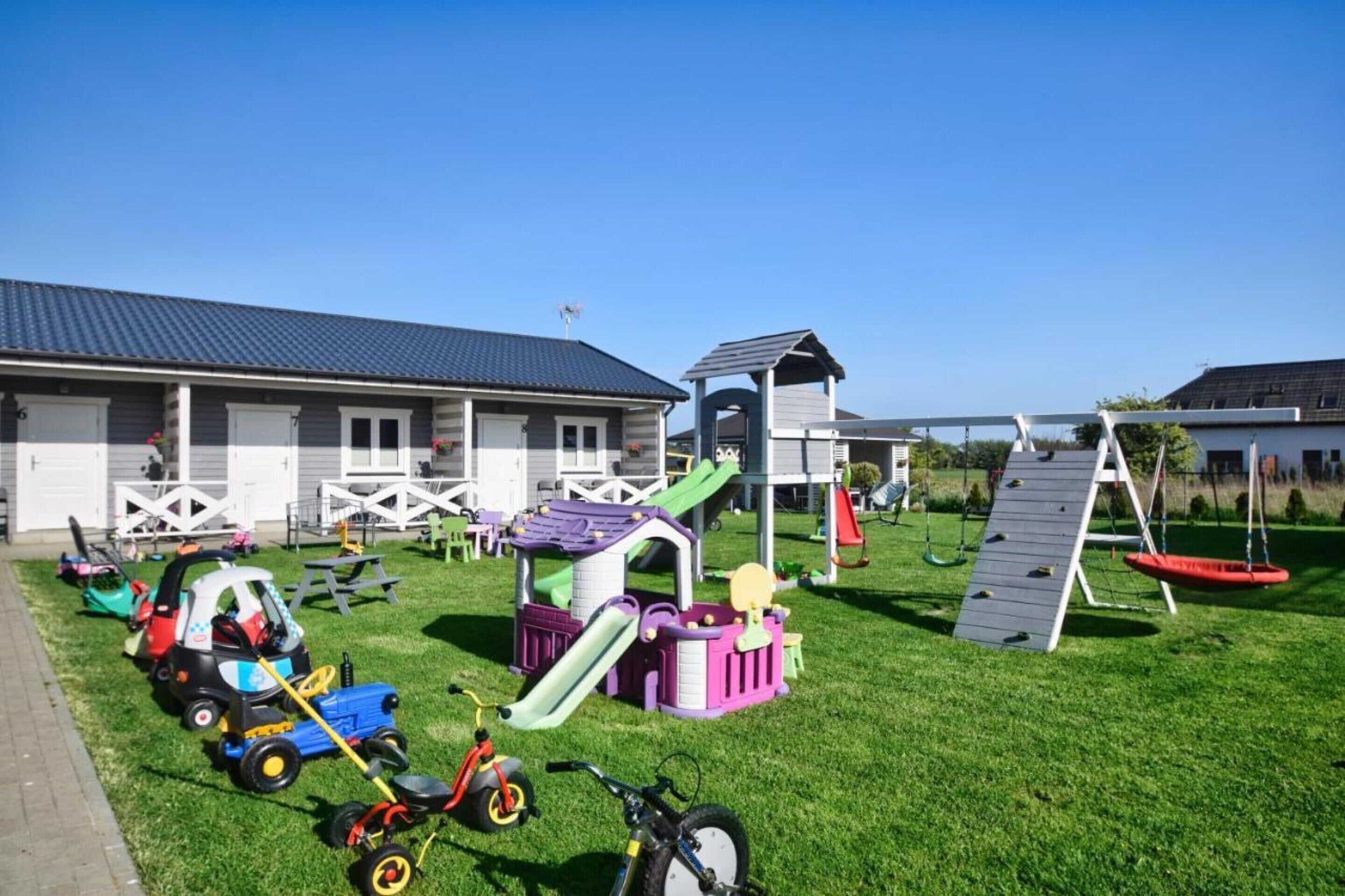 A children's play area with a slide, swing set, and various play structures.