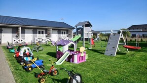 A children's play area with a slide, swing set, and various play structures. - Holiday Homes Close to the Beach, Large Playground (Mielno)