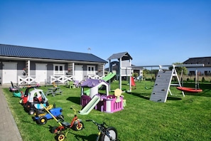 A children's play area with a slide, swing, and small house structure. - Holiday Homes Close to the Beach, Large Playground (Mielno)
