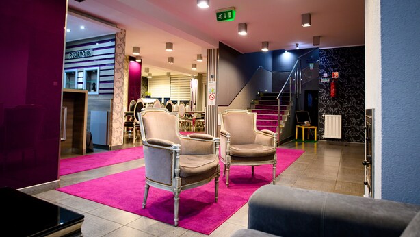 A lobby with two armchairs, a reception desk, and a staircase. - Palermó Panzió (Nyíregyháza)