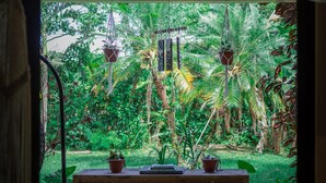 An interior space with a view of a lush garden. - Seahouse Beachfront B&B with Pool (Bocas del Toro)