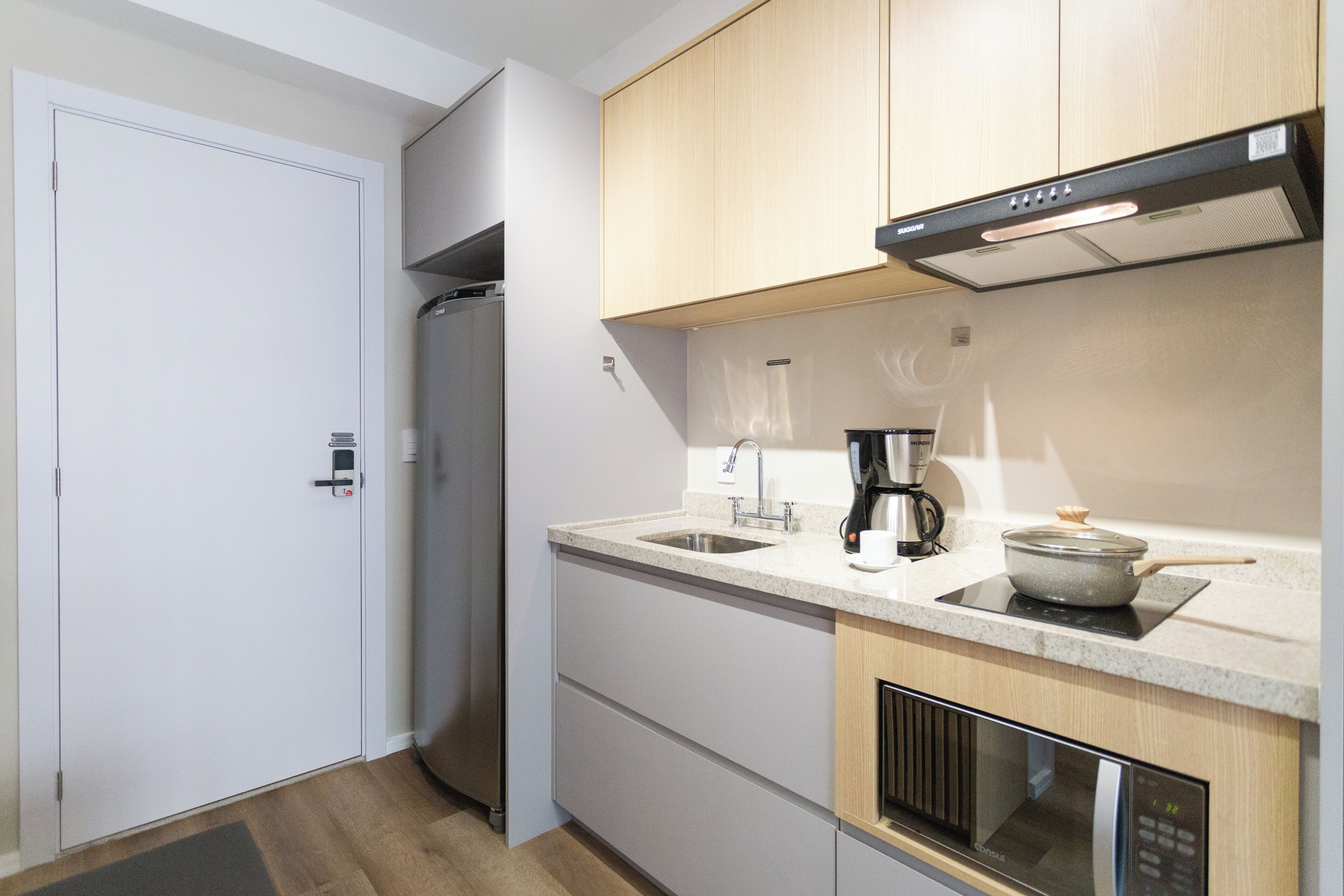 A modern kitchen with a built-in oven, a coffee maker, and a microwave.