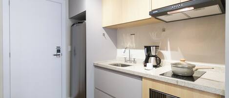 A modern kitchen with a built-in oven, a coffee maker, and a microwave.