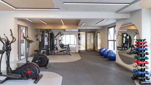 A modern gym with cardio machines, weightlifting equipment, and exercise balls. - HPaulista (São Paulo)