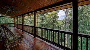 A wooden deck with a view of a forest.