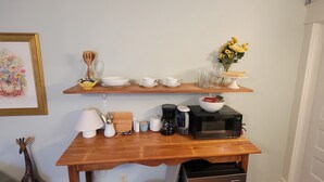 A kitchen with a wooden countertop, a microwave, a coffee maker, and a refrigerator. - Jude's cozy & convenient downtown studio Apt. (High Point)