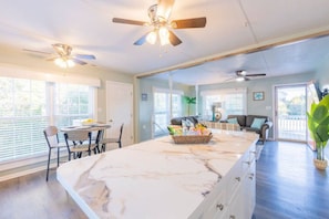 Relax in this spacious living area with a large island, dining table, and comfortable seating.