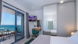 Hotellihuone, jossa on parveke, sänky, työpöytä ja televisio.