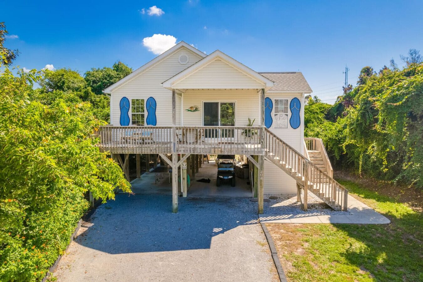 A two-story house with a balcony, a covered porch, and a driveway.