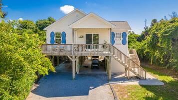 A two-story house with a balcony, a covered porch, and a driveway.