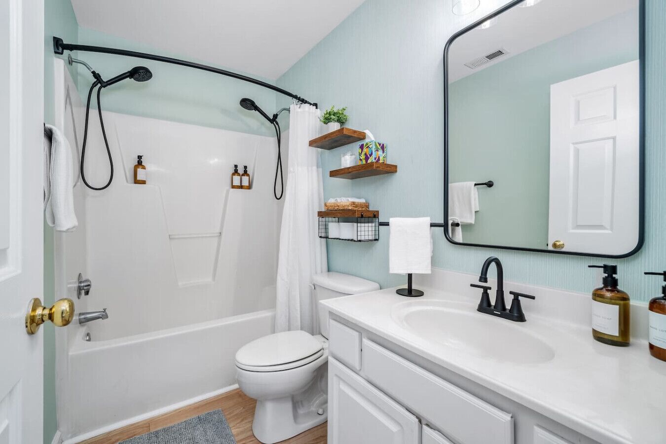 A modern bathroom with a shower, toilet, and sink.