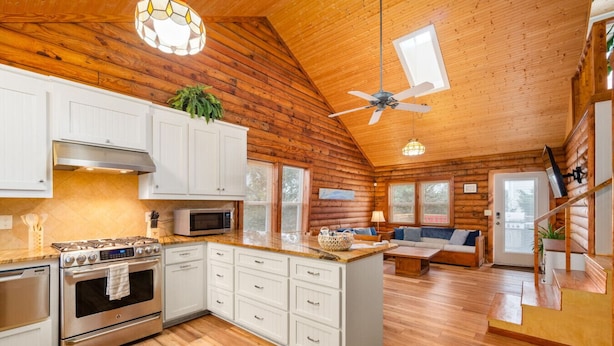 A log cabin interior with a kitchen, dining area, and a loft bedroom. - Cabin by the Sea|1-Min Beach·Projector Room·Log Cabin EI (Emerald Isle)