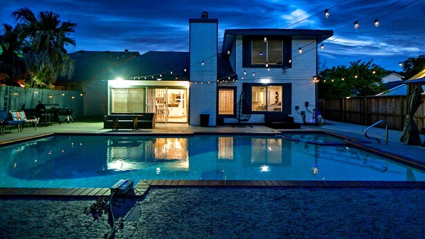 A modern house with a swimming pool, a patio, and string lights. - EXOTIC LODGE
Discover a unique retreat experience in the heart of Houston, TX (Houston)