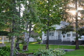A residential house with a front porch, surrounded by trees and a well-maintained lawn. - Spacious 3BR Retreat | Perfect for Families! (Indian River)
