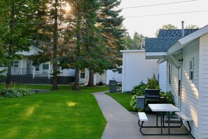 A residential area with a pathway leading to a white house with a patio.