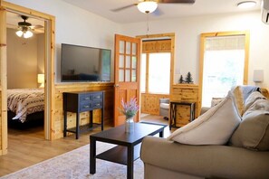 A cozy living room with a television, wooden furniture, and a sofa.