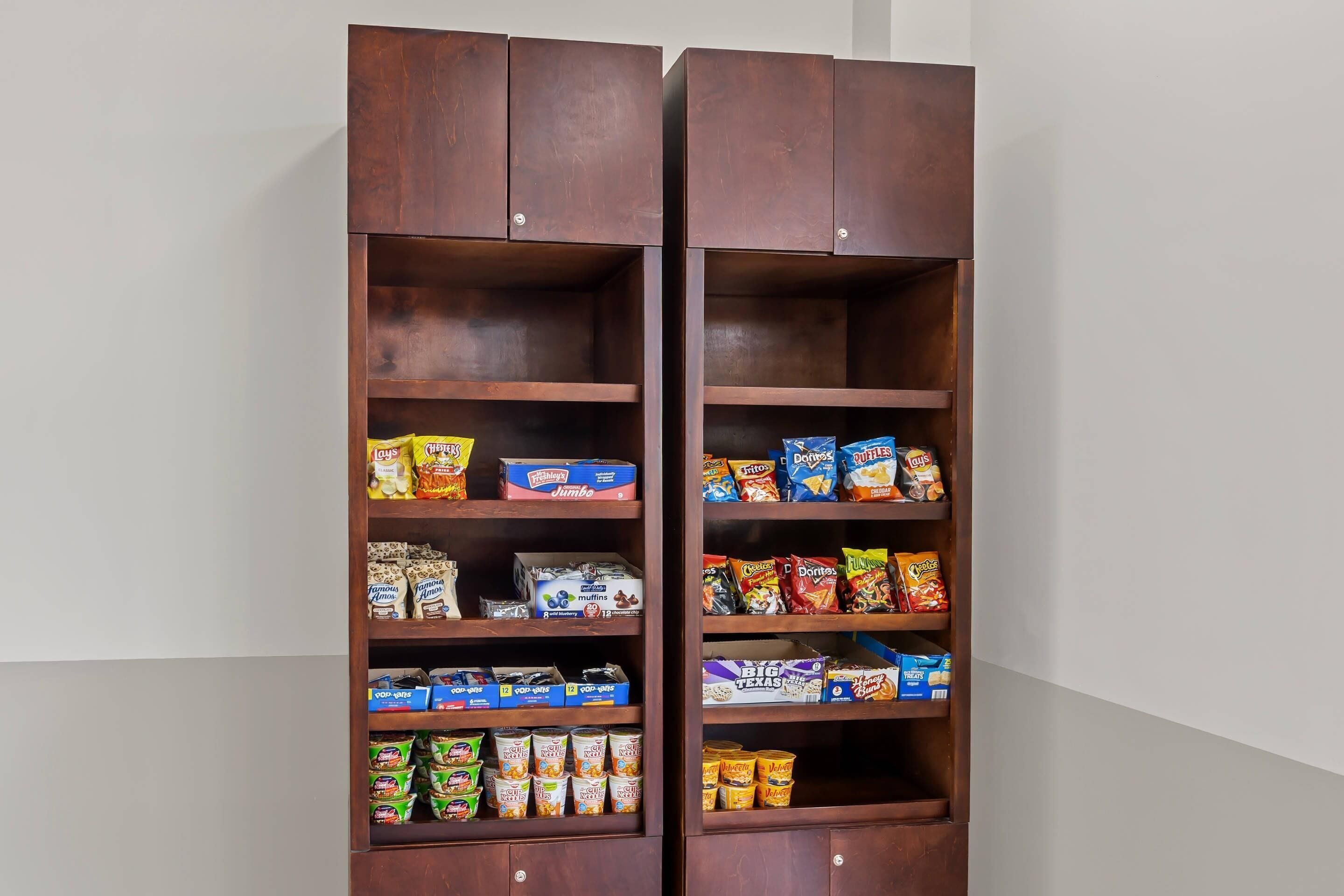 Un armario de madera con varios estantes que contienen diferentes alimentos.