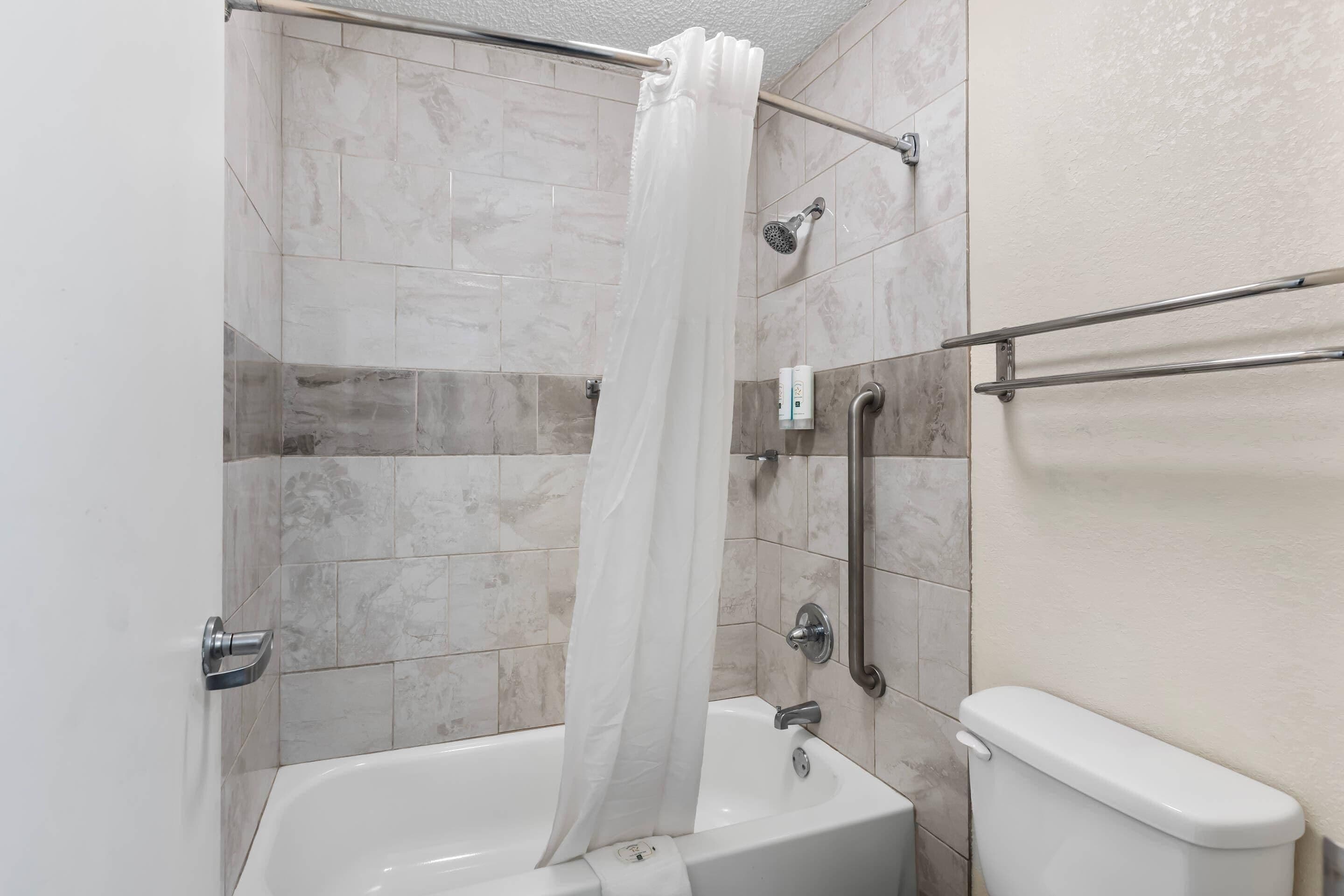 Une salle de bain avec une baignoire, une douche et des toilettes.