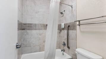 Une salle de bain avec une baignoire, une douche et des toilettes.