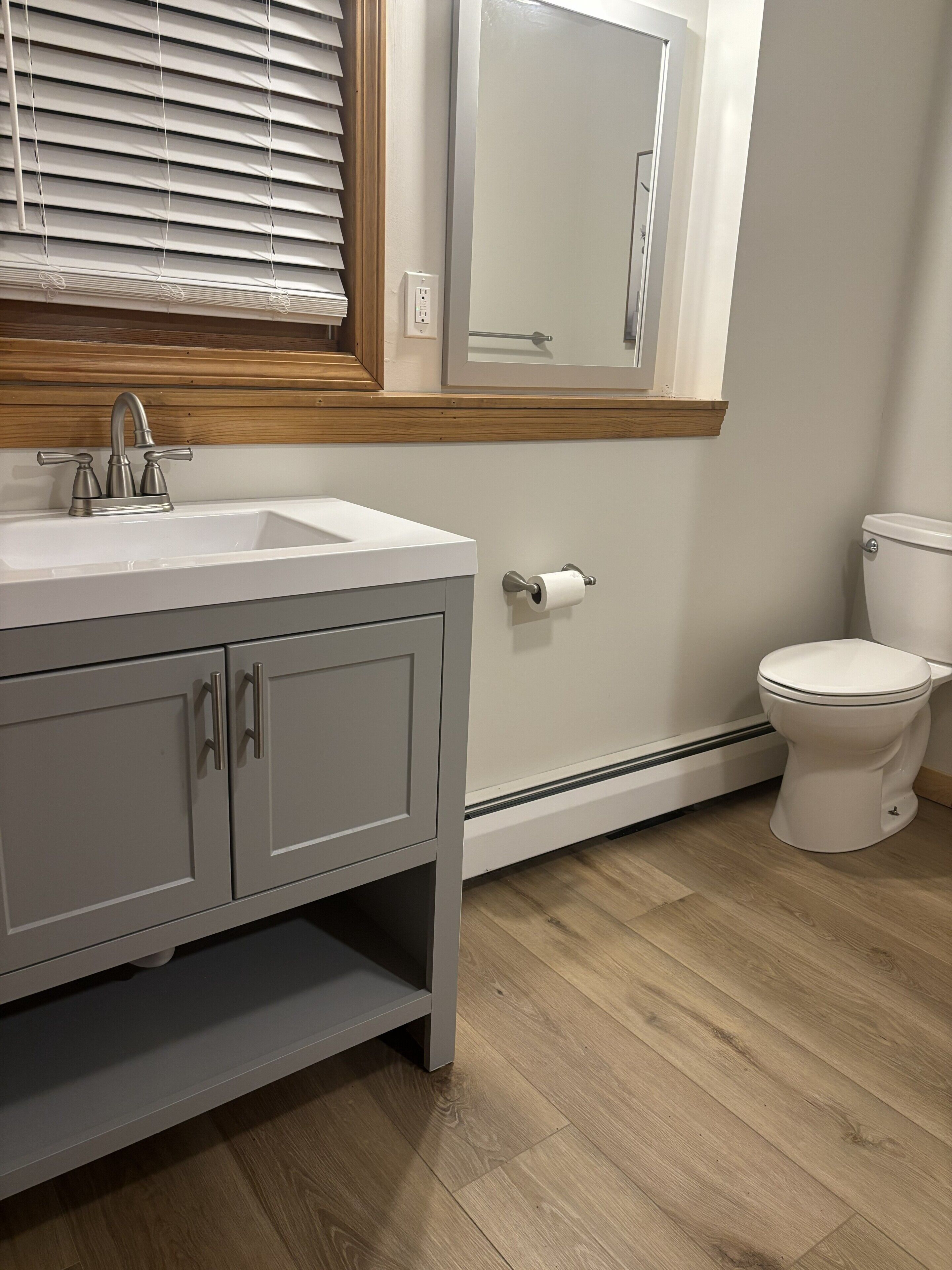 Un baño con lavabo, inodoro y espejo.